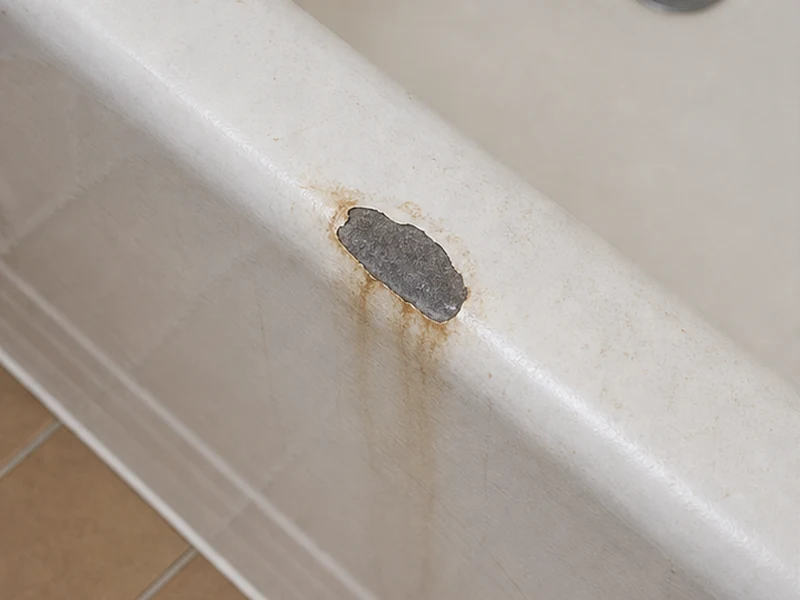 Chipped and rust-stained tub rim before repair in a Santa Clara home